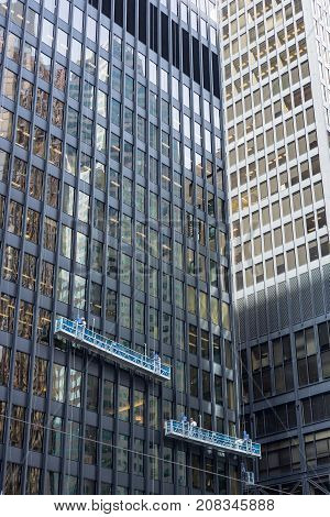 two window cleaning crews working in different heights at office towers in the financial district downtown Toronto
