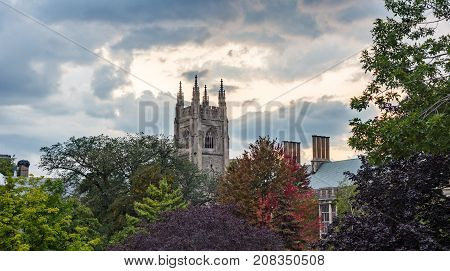 beautiful dramatic cloudy sky at sunsut hidden castle tower behind colorful trees in autumn colors
