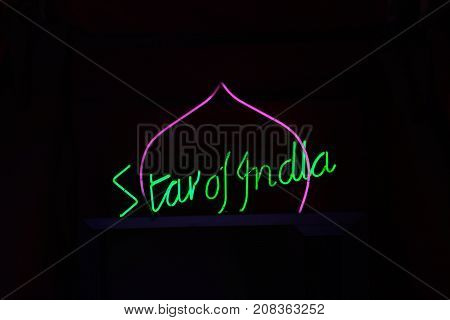 SAN PAWL, MALTA - APRIL 2, 2017 - Green and pink neon Star of India restaurant sign against a black background San Pawl Malta Europe, April 2, 2017.