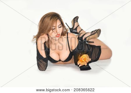 Pretty Asian woman witch in black bikini lying on isolated background.