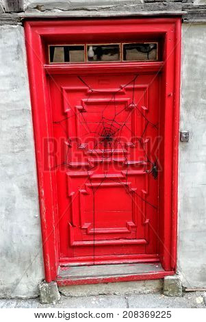 Antique red door and black spider web.