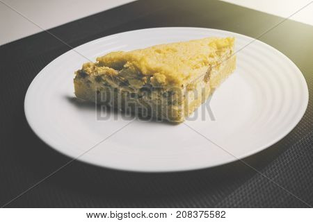 Peach pie on black and white background with sunlight from side. Yellow Peach pie on the table in kitchen. Peach pie with apricot.