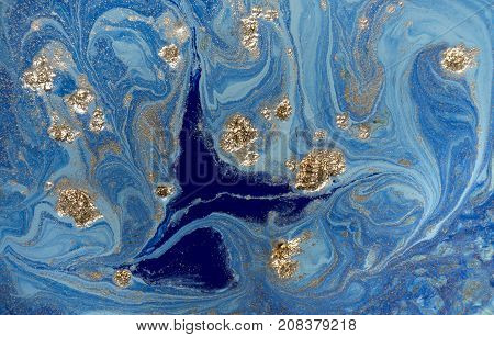 Marbled blue abstract background with golden sequins. Liquid marble ink pattern