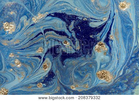 Marbled blue abstract background with golden sequins. Liquid marble ink pattern