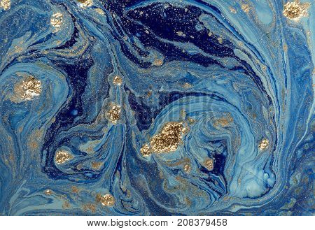 Marbled blue abstract background with golden sequins. Liquid marble ink pattern