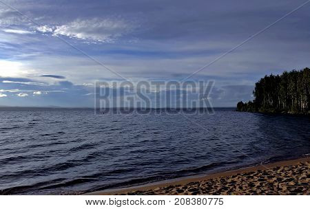 hazy sun over the lake shines through the gray clouds, South Ural, Uvildy