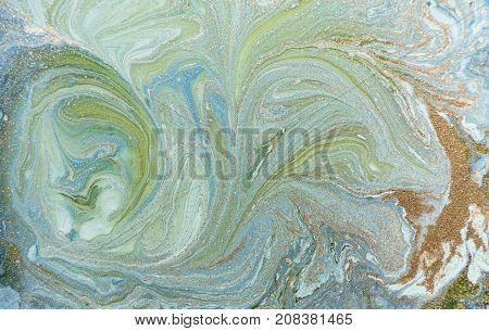 Marbled blue abstract background with golden sequins. Liquid marble ink pattern