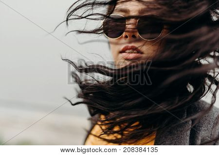Portrait Of Stylish Modern Young Curly Woman In Coat Sunglasses