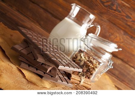 Chocolate, Jug Of Milk, Cinnamon, Cocoa And Mixed Nuts In A Jar
