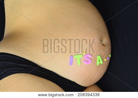 Pregnant woman with words on het belly, its a