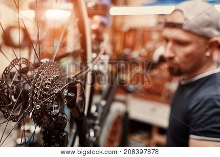 Mechanic repairing bicycle in his workshop. Bicycle service.