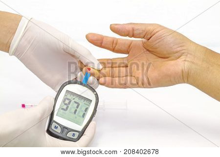 blood glucose meter the blood sugar value is measured on a finger by female doctor in white medical gloves