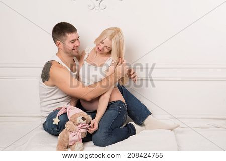 Beautiful pregnant couple in love on the background. Hands of husband on the tummy of his pregnant wife. Young man tenderly stroked pregnant belly of his wife. Husband kissing pregnant belly.