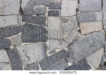The polished pieces of gray granite paved road.