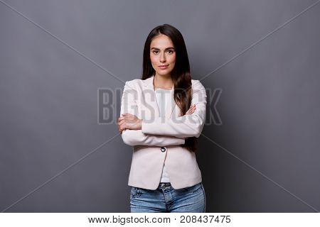 Beautiful businesswoman studio shot on grey background. Charming and confident serious brunette woman in casual jacket