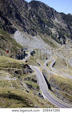 Red cable car in the mountains over the road- Carphatians
