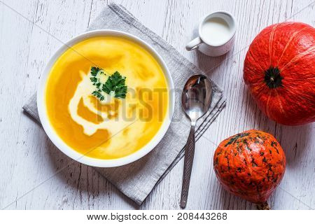 Pumpkin soup with cream and parsley. Vegan food. Top view.