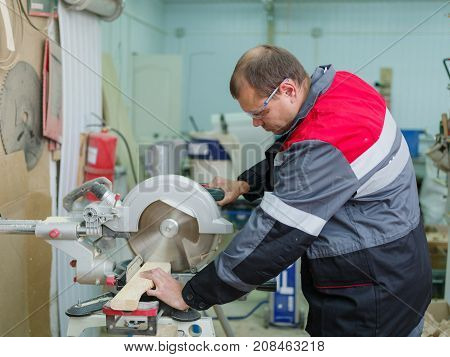 Gray machine circular saw with protection so as not to harm yourself, against the background of the fire extinguisher