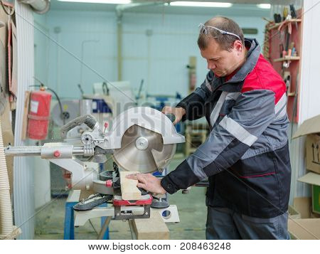 Gray machine circular saw with protection so as not to harm yourself, against the background of the fire extinguisher