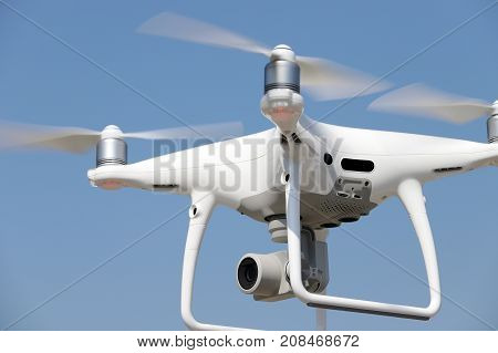 KAGAWA, JAPAN - OCTOBER 10, 2017: White remote controlled Drone Dji Phantom4 Pro equipped with high resolution video camera flying in air and blue sky in the background