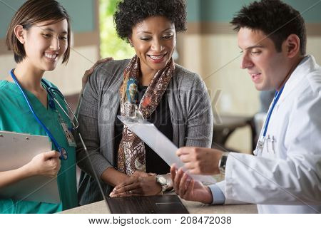 Medical team talking with a patient in the doctors office.