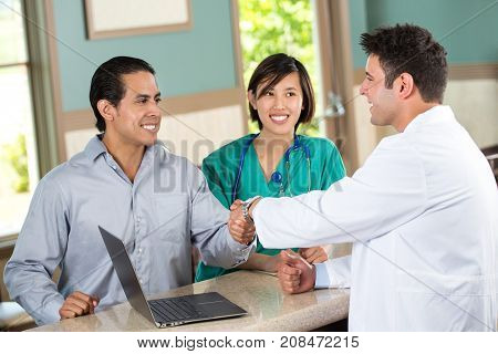Medical team talking with a patient in the doctors office.