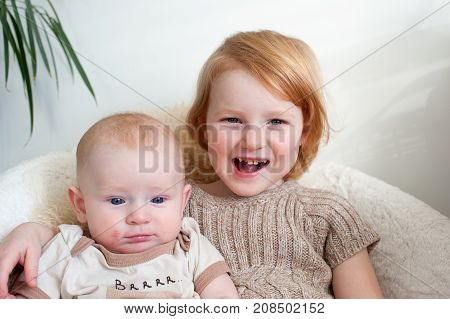 Boy with dermatitis and a girl with caries sitting on a chair