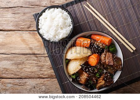 Korean Stewed Beef Short Ribs With Vegetables And Rice Garnish Close-up. Horizontal Top View