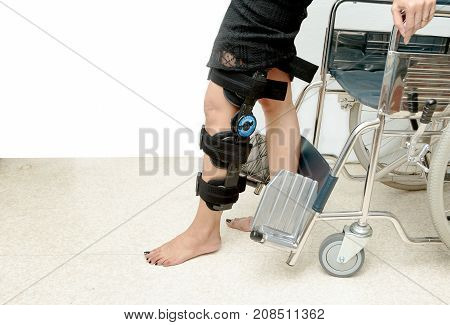 Patient On Knee Brace Support Try To Walk Training,rehabilitation Treatment