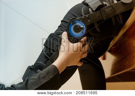 Physiotherapist adjust knee braces on patient 's leg in hospital