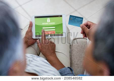 Internet banking text on phone display against senior couple doing online shopping on digital tablet