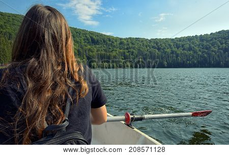 Teen girl back view sailing on lake