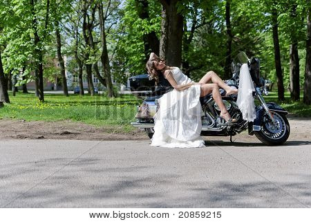 Belle jeune mariée assis sur une moto