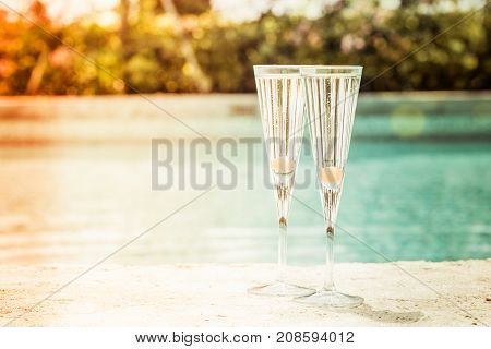 Two Glasses Of Prosecco Cocktail With Orange Berry At The Edge Of A Resort Pool. Concept Of Luxury V