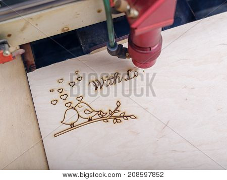 Automated machine for the burning of patterns on the tree began its work on patterns and inscriptions close-up