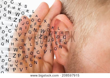 Man Holding Hand Near Ear And Listening Carefully Alphabet Letters Fly
