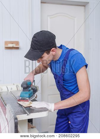 A carved plate on which the patterns and inscriptions are burned out that the master in blue overalls handle with a special tool