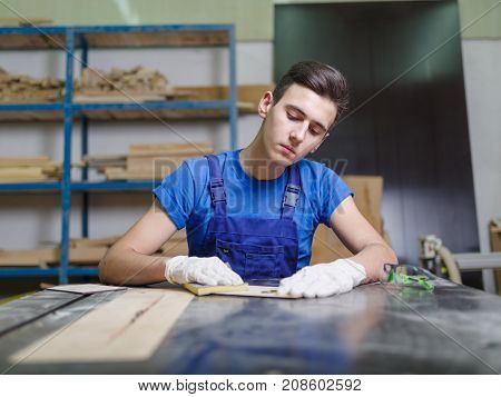 A carved plate on which the patterns and inscriptions are burned out that the master in blue overalls handle with a special tool