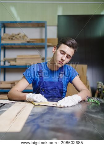 A carved plate on which the patterns and inscriptions are burned out that the master in blue overalls handle with a special tool