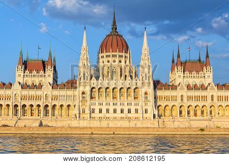 The symmetrical main facade and the central dome of the Hungarian Parliament Building overlook the River Danube - Budapest, Hungary