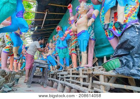 KUMARTULI KOLKATA INDIA - OCTOBER 10 2014 - Artist preparing clay idols of female demons to be used during Kali Puja worshipping of Goddess Kali Hindu festival of Deepavali or Diwali.