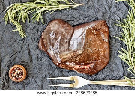 Healthy Fod Raw Liver With Rosemary On A Black Background