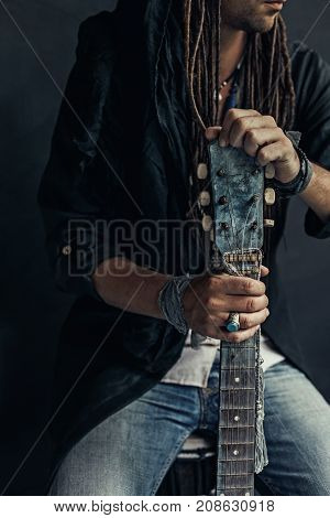 gypsy hippie styled young man with guitar close up portrait