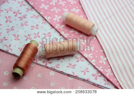 Multicolored cuts of fabric with coils of thread on the background of boards