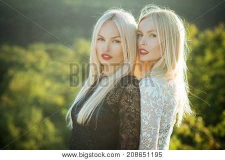 Two Women With Red Lips And Long Blond Hair