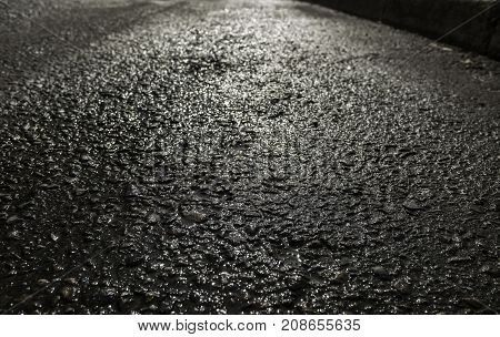 Asphalt after the rain. Texture of asphalt road. Light reflection on asphalt. Grunge asphalt. Asphalt background. Asphalt texture. Asphalt road.