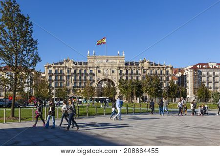 SANTANDER SPAIN - OCTOBER 7 2017: Tourists stroll on the Paseo Pereda boulevard in front of the heaquarters building of Banco de Santander.