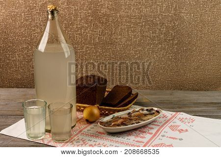 Ukrainian National Drink And Snack. The Big Bottle And Glass Of Moonshine On The Old Wooden Table