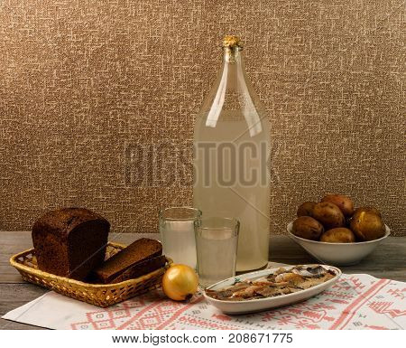 Ukrainian National Drink And Snack. The Big Bottle And Glass Of Moonshine On The Old Wooden Table