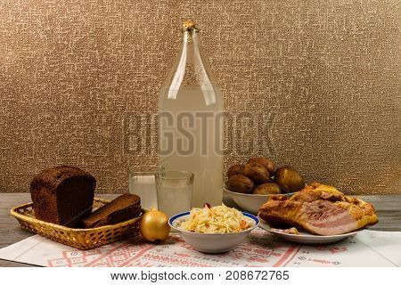 Ukrainian National Drink And Snack. The Big Bottle And Glass Of Moonshine On The Old Wooden Table